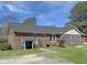 Charming brick home with screened porch, well-maintained lawn, and inviting curb appeal at 243 Country Club Blvd, Saint George, SC 29477