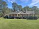 Charming brick home with a cozy front porch, mature trees, and a well-manicured lawn at 243 Country Club Blvd, Saint George, SC 29477