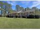 Inviting brick home with a covered front porch, lush landscaping, and a sprawling green lawn at 243 Country Club Blvd, Saint George, SC 29477