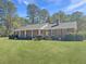 Classic brick ranch-style home featuring a covered front porch and a lush, green lawn at 243 Country Club Blvd, Saint George, SC 29477