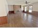 Spacious living room featuring a brick fireplace, wood paneling, and a ceiling fan at 243 Country Club Blvd, Saint George, SC 29477
