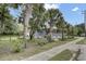 Home exterior showcases a wrap-around porch and landscaped yard with mature palm trees at 2530 Jasper Blvd, Sullivans Island, SC 29482