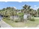Home with a screened porch, surrounded by palm trees and lush greenery, adding to its charm at 2530 Jasper Blvd, Sullivans Island, SC 29482