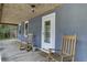 Cozy porch featuring rocking chairs, classic details and a door leading into the home at 2530 Jasper Blvd, Sullivans Island, SC 29482