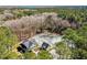 An aerial view shows a house and detached garage nestled among lush trees, with a partial view of a body of water at 2725 Starfish Dr, Johns Island, SC 29455