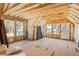 Unfinished attic with exposed rafters and multiple windows for natural light at 2725 Starfish Dr, Johns Island, SC 29455