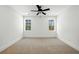 Bright bedroom features neutral carpet, two windows, modern ceiling fan, and crisp white walls at 2725 Starfish Dr, Johns Island, SC 29455