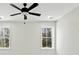 Bright bedroom features a ceiling fan and double hung windows overlooking a wooded landscape at 2725 Starfish Dr, Johns Island, SC 29455