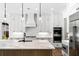 A modern kitchen features an oversized island, stainless appliances, and custom cabinetry at 2725 Starfish Dr, Johns Island, SC 29455