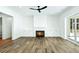 Open living room showcasing a modern fireplace, shiplap accent wall, and wood flooring at 2725 Starfish Dr, Johns Island, SC 29455