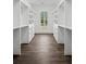 Bright walk-in closet with custom shelving, drawers and a window offering natural light and hardwood floors at 2725 Starfish Dr, Johns Island, SC 29455