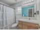 Full bathroom with shower-tub combo, bright blue accent wall, and laminate countertop at 2755 Lacy St, North Charleston, SC 29406