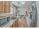 Galley kitchen with light wood cabinets, stainless steel appliances, and laminate flooring at 2755 Lacy St, North Charleston, SC 29406