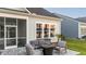 Outdoor patio with a seating area around a fire pit, screened-in porch, and stone paver patio at 357 Tupelo Lake Dr, Summerville, SC 29486