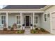The front porch features decorative columns, comfortable seating and professionally arranged landscaping at 357 Tupelo Lake Dr, Summerville, SC 29486