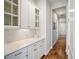 Hallway with white cabinets, display shelves, drawers, light countertops, and hardwood floors at 357 Tupelo Lake Dr, Summerville, SC 29486