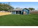 Spacious backyard with lush green grass, blue house with back porch, and wood fence at 39 Briarcliff Dr, Charleston, SC 29407