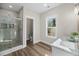 Bright bathroom with tile shower, wood-look flooring, and marble countertop sink at 39 Briarcliff Dr, Charleston, SC 29407