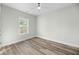 Bright bedroom featuring wood-look floors, light-colored walls and ceilings, ceiling fan, and a large window at 39 Briarcliff Dr, Charleston, SC 29407