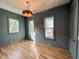 Stylish bedroom with green walls, three windows, hardwood flooring, and modern lighting at 3902 Summerton St, Mount Pleasant, SC 29466