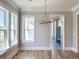 Well-lit dining room with hardwood floors, an elegant chandelier, and large windows offering views of the outdoors at 3902 Summerton St, Mount Pleasant, SC 29466