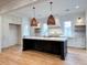 Spacious kitchen with white cabinets, a dark island, stone countertops, and stylish pendant lighting at 3902 Summerton St, Mount Pleasant, SC 29466