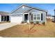 Charming one-story home featuring blue siding, a well-manicured lawn, and an attached garage on a sunny day at 400 Hampstead Ct, Summerville, SC 29486