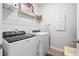 Well-lit laundry room equipped with modern washer and dryer units and convenient shelving at 400 Hampstead Ct, Summerville, SC 29486