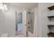Bathroom with tub and shower combo and storage shelving; natural light shines through the doorway at 4336 Purdue Dr, North Charleston, SC 29418
