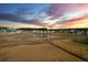 Sunset over the community pond, reflecting colors amid homes and fences, showcasing a tranquil evening at 4368 Ocean Farm Dr, Summerville, SC 29485