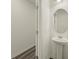 Half bathroom with a pedestal sink, oval mirror, and wood-look floors, next to the entryway at 4368 Ocean Farm Dr, Summerville, SC 29485