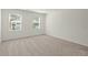 Bedroom with neutral carpet, white walls, and two windows with views of the neighborhood at 4368 Ocean Farm Dr, Summerville, SC 29485