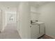 Convenient laundry area with washer, dryer, and shelving, located just off the hallway, enhancing functionality at 4368 Ocean Farm Dr, Summerville, SC 29485