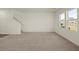 Bright living room featuring neutral carpet, white walls, and staircase at 4368 Ocean Farm Dr, Summerville, SC 29485