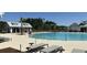 A community pool with several lounge chairs and tables, with a pool house in the background at 4368 Ocean Farm Dr, Summerville, SC 29485