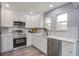 Modern kitchen featuring stainless steel appliances, white cabinets, and light stone countertops at 4618 Moss Ct, Charleston, SC 29420