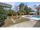 Landscaped backyard with a pool, jacuzzi, firepit, wooden seating, and various greenery at 4634 O'Hear Ave, North Charleston, SC 29405