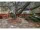 Secluded backyard with a stone patio, shade tree, and natural landscaping, ideal for relaxation at 4634 O'Hear Ave, North Charleston, SC 29405