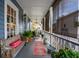 Inviting porch with a wooden bench, ferns, and rug, creating a cozy outdoor living space at 48 Montagu St # B, Charleston, SC 29401