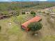Aerial view of horse property with a large red barn, paddocks, and green fields, surrounded by trees at 4801 Coon Club Rd, Meggett, SC 29449