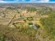 Expansive estate with private pond, pool, and outbuildings surrounded by lush landscaping and a secure red perimeter at 4801 Coon Club Rd, Meggett, SC 29449