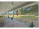 Relaxing covered porch with ceiling fan, offering peaceful views of the expansive yard and mature trees beyond at 4801 Coon Club Rd, Meggett, SC 29449