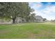 Spacious backyard with lush green grass and mature trees, featuring a charming single story home with a classic design at 4801 Coon Club Rd, Meggett, SC 29449