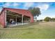 The red barn features open bays and enclosed storage with a yard and equipment nearby at 4801 Coon Club Rd, Meggett, SC 29449