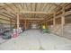 Interior view of a barn with a concrete floor, open framework, and farm equipment at 4801 Coon Club Rd, Meggett, SC 29449