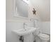 Bathroom featuring a pedestal sink, toilet, white wainscoting and neutral paint at 4801 Coon Club Rd, Meggett, SC 29449