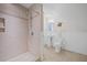 Bright bathroom with a tiled shower, toilet, and pedestal sink with neutral color palette at 4801 Coon Club Rd, Meggett, SC 29449