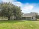 Charming single-story home features a sprawling lawn, mature trees, and a welcoming front porch at 4801 Coon Club Rd, Meggett, SC 29449