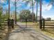 Grand gated entrance to the property, showcasing a long driveway and lush landscaping, promising privacy and elegance at 4801 Coon Club Rd, Meggett, SC 29449