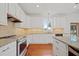 Modern kitchen featuring white cabinets, stainless steel appliances, granite countertops, and an abundance of natural light from the window at 4801 Coon Club Rd, Meggett, SC 29449